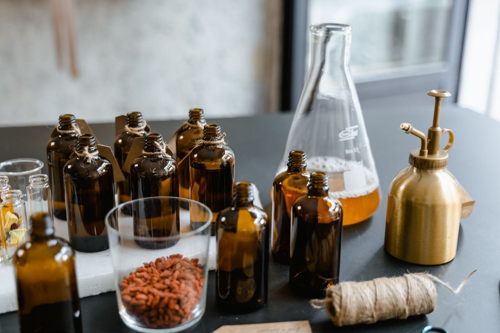 Amber fragrance bottles and botanicals on the CORE atelier worktable